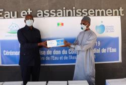 Mr. Mamadou DIA (right), Governor of the World Water Council representing President Loïc Fauchon, hands over a batch of soap to Mr. Serigne Mbaye Thiam, Senegalese Ministry of Water and Sanitation, during the ceremony on April 24, 2020.